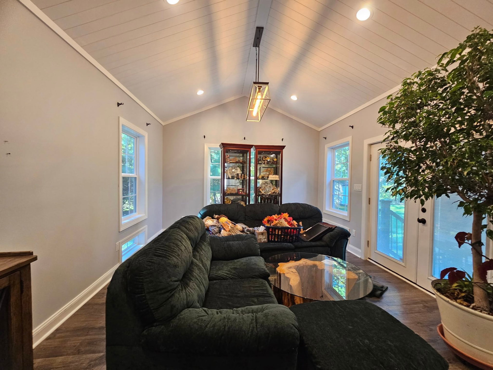 Living room with a white painted shiplap vaulted ceiling and warm greige walls