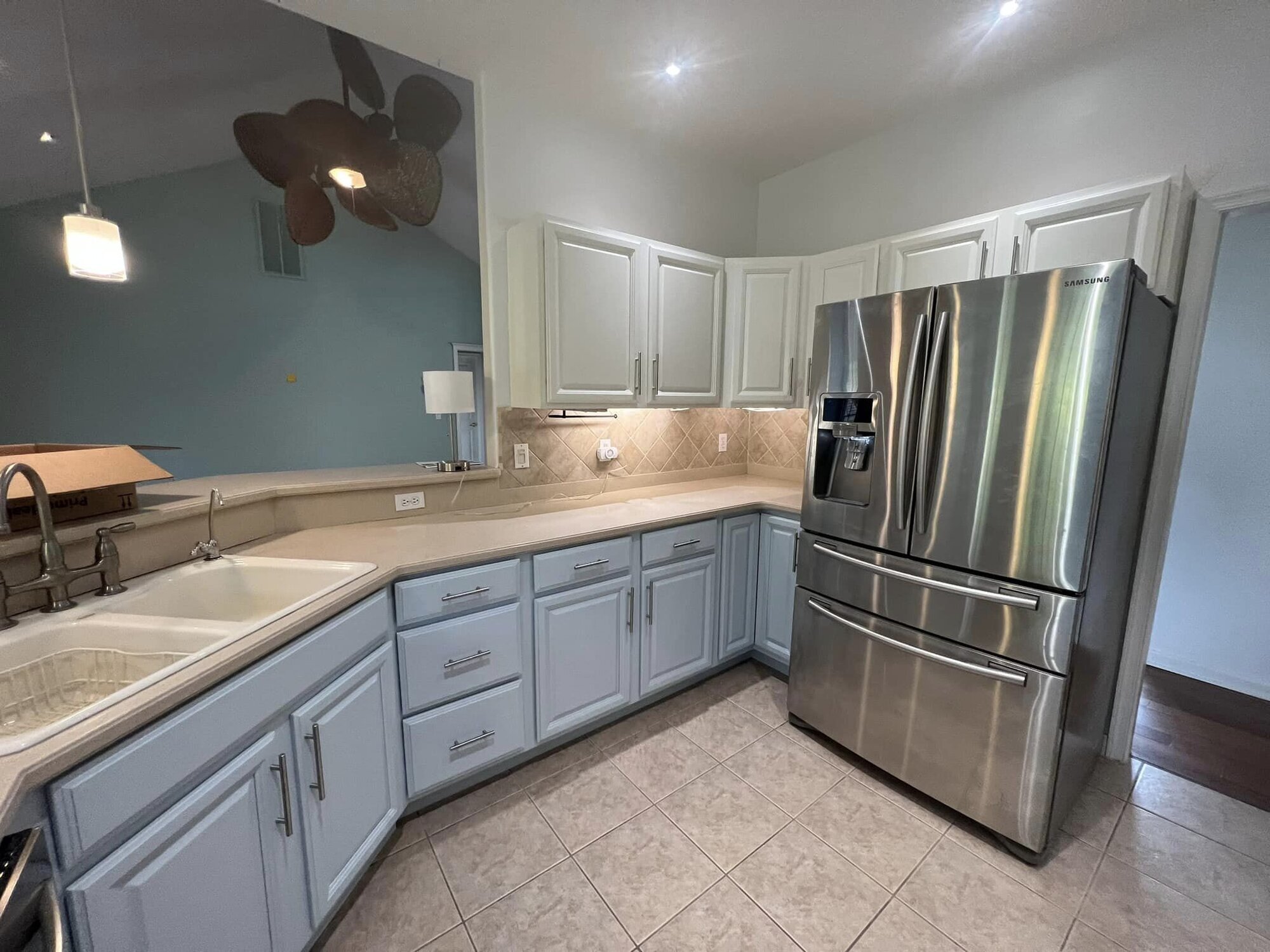 Kitchen with cabinets refinished in a soft coastal blue-grey and brushed nickel hardware