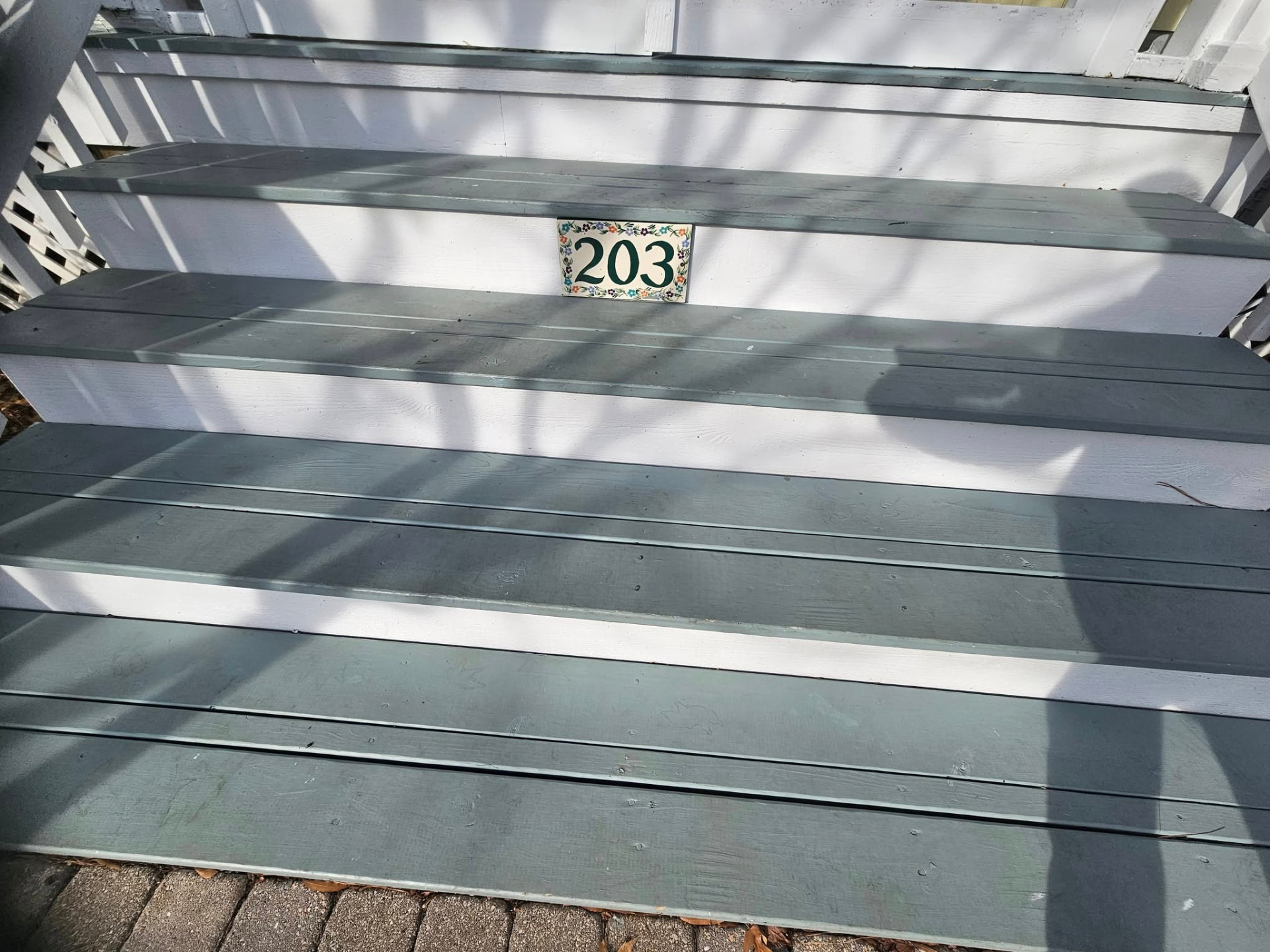 Same porch steps refinished in a clean slate blue-green with bright white risers
