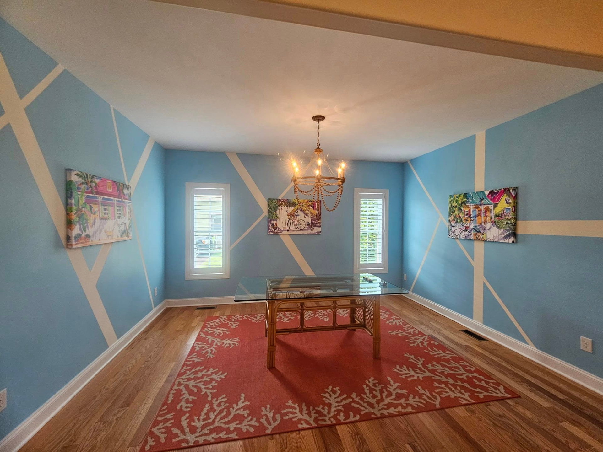 Dining room painted coastal blue with a hand-taped white geometric pattern across all four walls